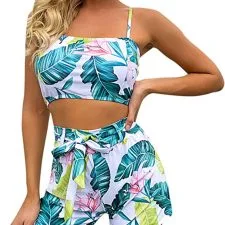 Conjunto de baño de dos piezas con hojas verdes y flores sobre fondo claro.