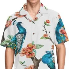 Camisa blanca de manga corta con pavos reales azules y flores.