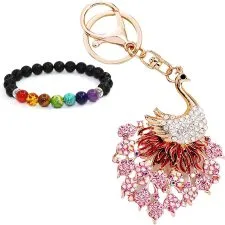 Llavero con un ave blanca de cuello curvado y adornos rosas, junto a una pulsera.