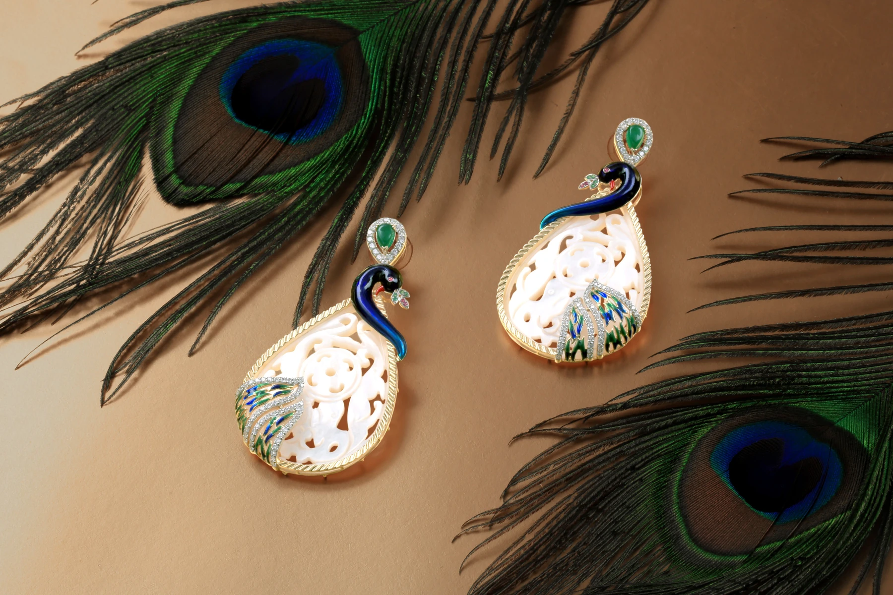Pendientes con siluetas de pavo real, detalles verdes y azules y acabado dorado.