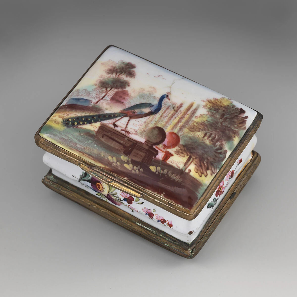 Caja histórica esmaltada con un pavo real azul y su larga cola pintados en la tapa.