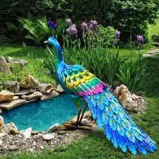 Figura de pavo real multicolor junto a un pequeño estanque de jardín.